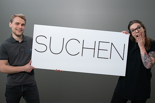 maennliche und weibliche person halten schild mit suchen