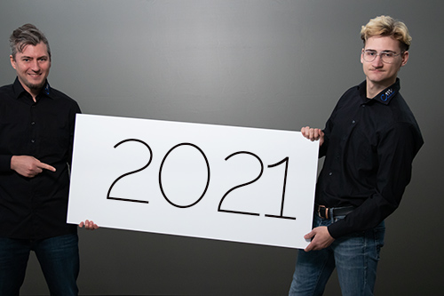 zwei maennliche personen halten schild mit 2021