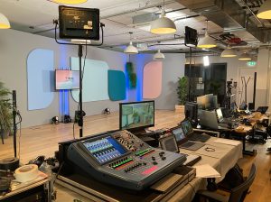 veranstaltung mit blick aus der technik, mischpult, buehne, leinwand und bildschirme zu sehen