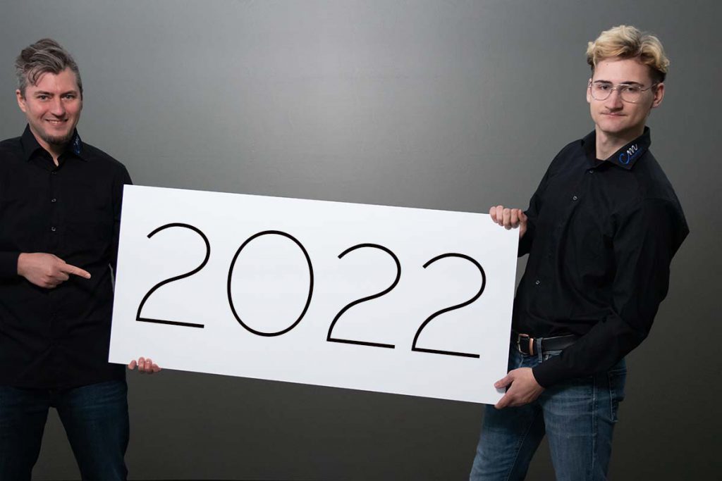 zwei maennliche personen halten schild mit text 2022
